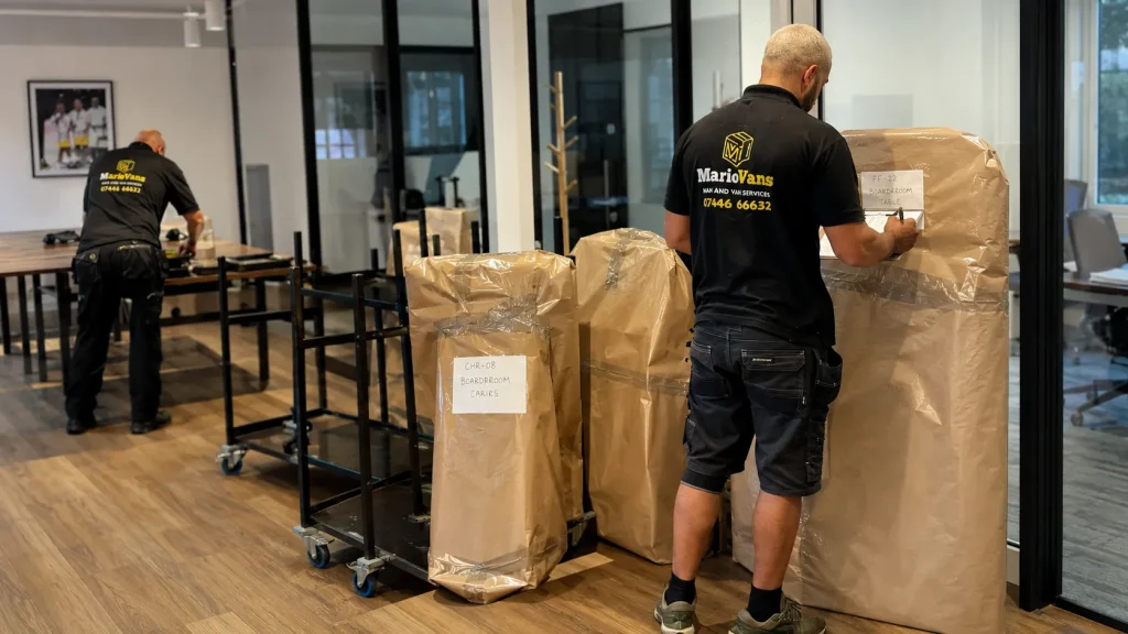 MarioVans team organising office furniture and boxes using a relocation inventory