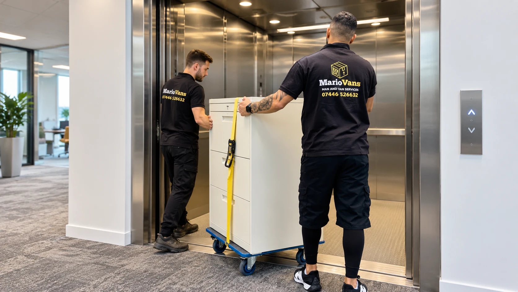 MarioVans movers guiding a filing cabinet on a trolley into a service lift