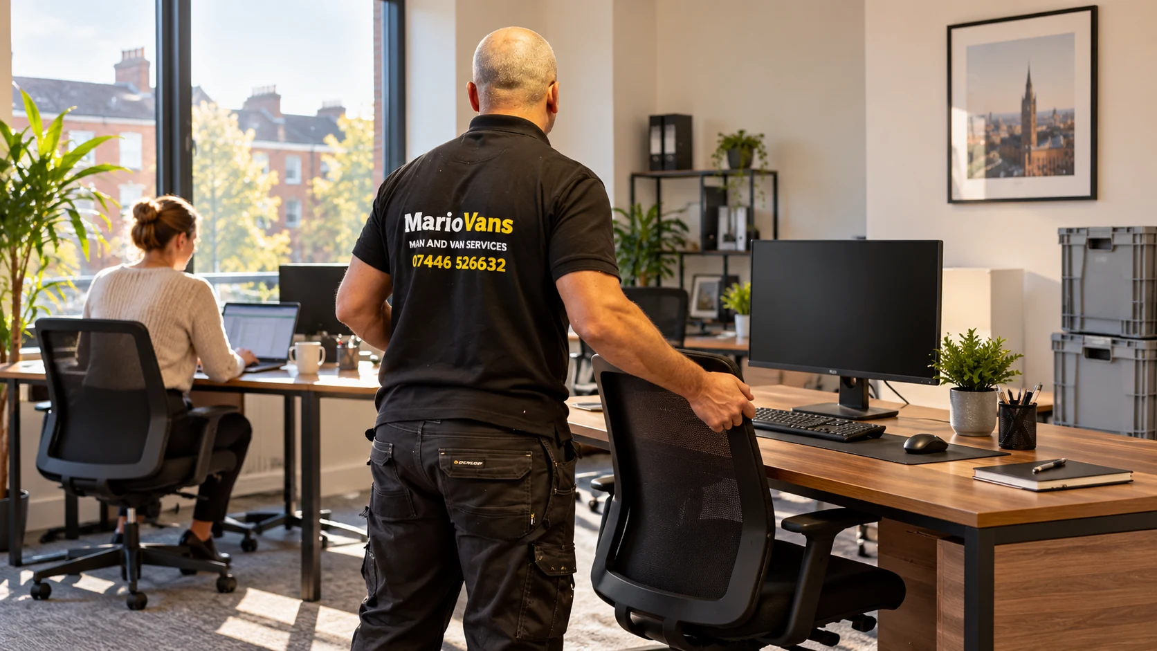 MarioVans mover positioning a chair while an office coordinator checks a laptop
